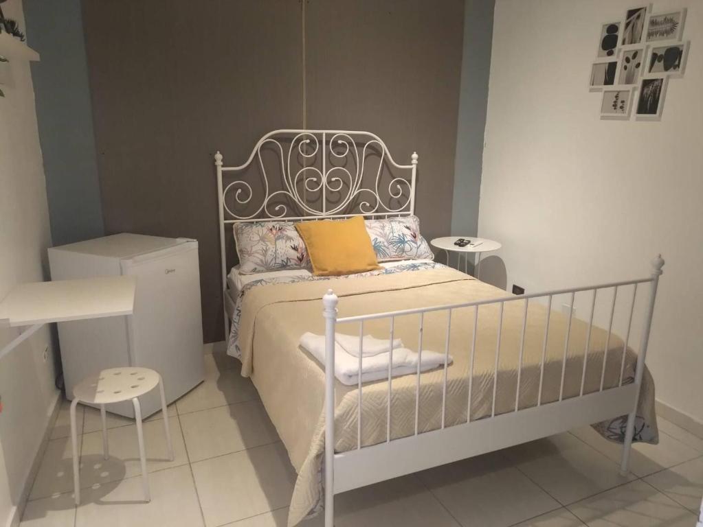 a small bedroom with a white bed and a table at A Night at Zona colonial in Santo Domingo