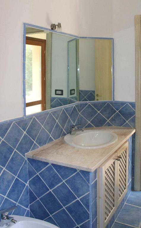 a bathroom with a sink and a mirror at Sa Tirìa in Chia