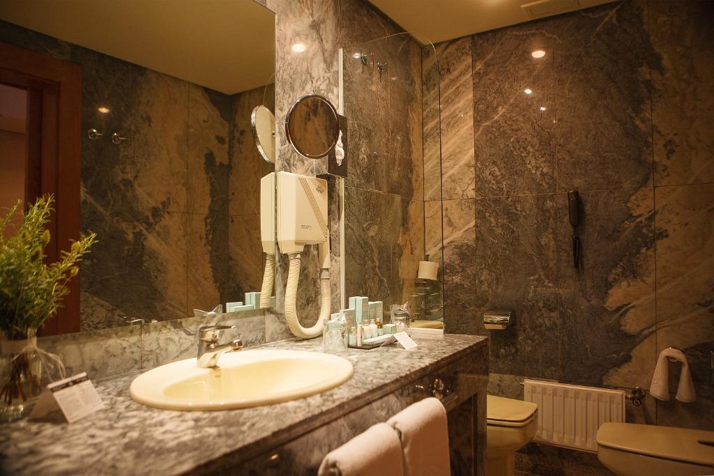 een badkamer met een wastafel en een spiegel bij Parador de Segovia in Segovia