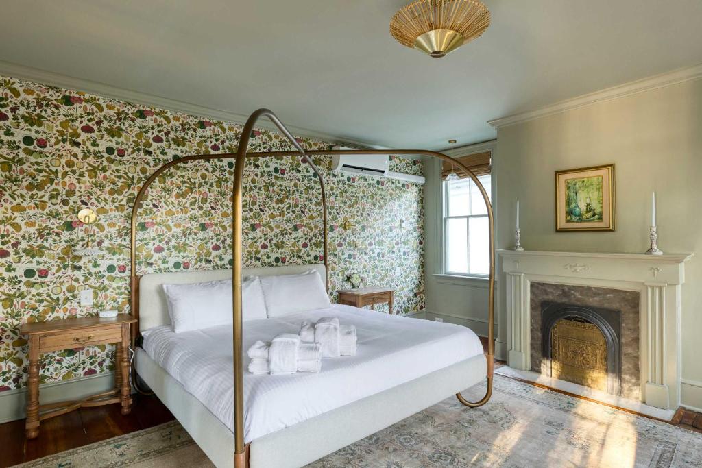 a bedroom with a bed and a fireplace at The Nicholas Veranda King Suite - Steps to King in Charleston