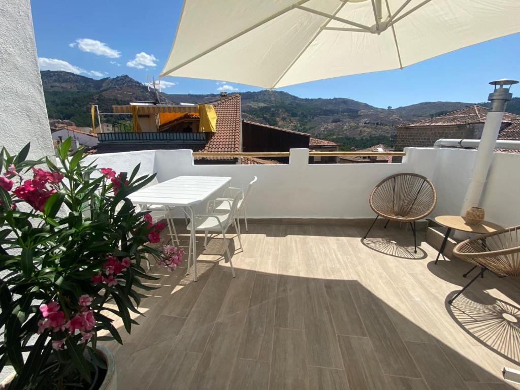 a patio with a table and chairs and an umbrella at El Palomar in El Arenal