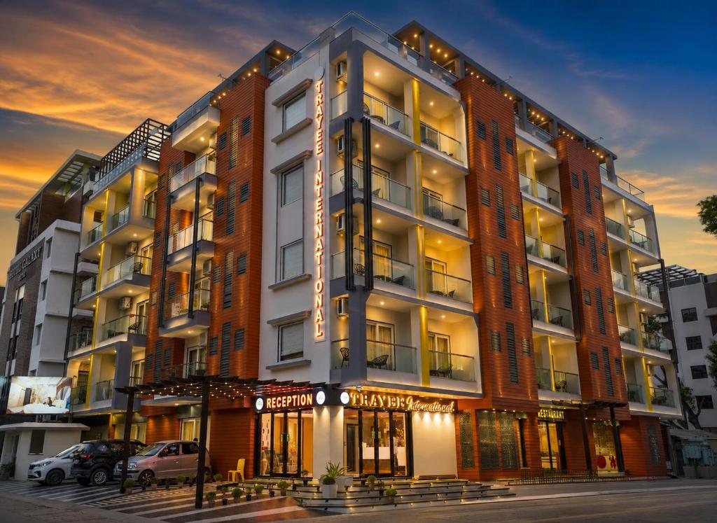 a large apartment building with a lit up facade at Trayee International in Digha