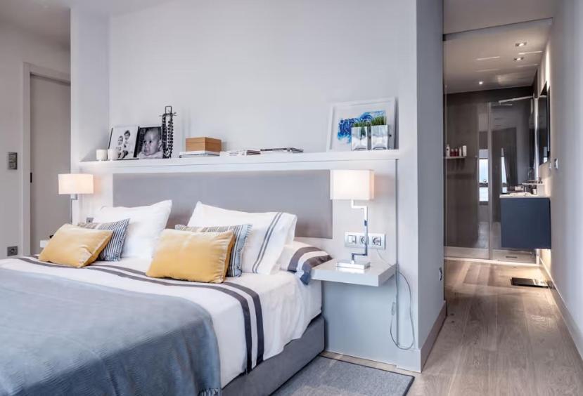 a bedroom with a large bed with a desk and lamps at Anwill Suite in Barranquilla