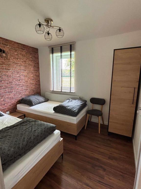 a room with two beds and a chair in it at Domek Wśród Pisarzy in Strawczynek