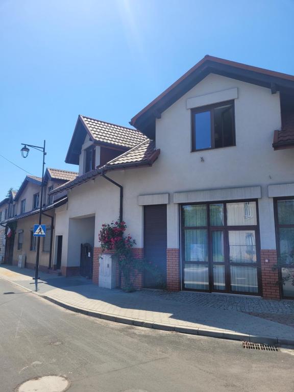 a white house on the side of a street at Termalne Pokoje in Uniejow