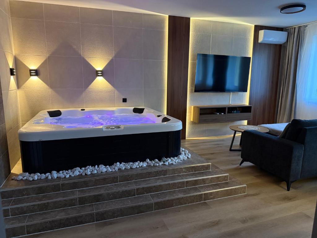 a large bath tub in a living room with a tv at Heaven SPA Eger in Eger