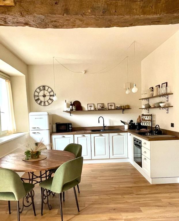 a kitchen with a wooden table and chairs and a table and a sink at La Morra Relax in La Morra