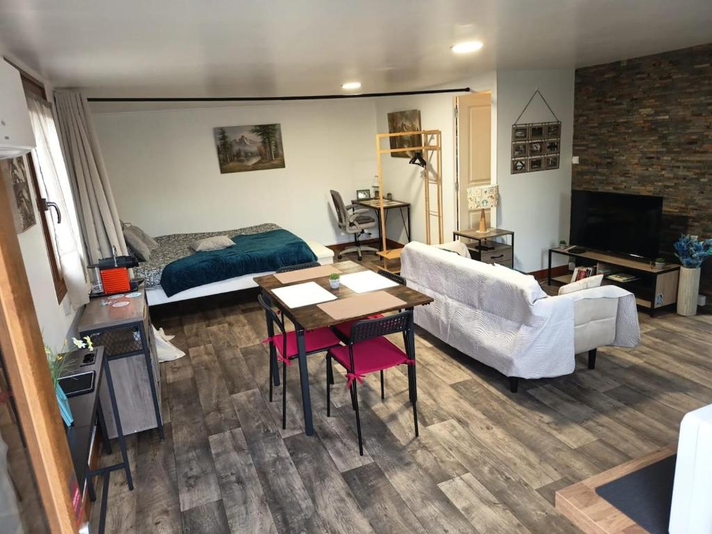 a living room with a couch and a bed and a table at L'Escapade Vierzonnaise in Vierzon
