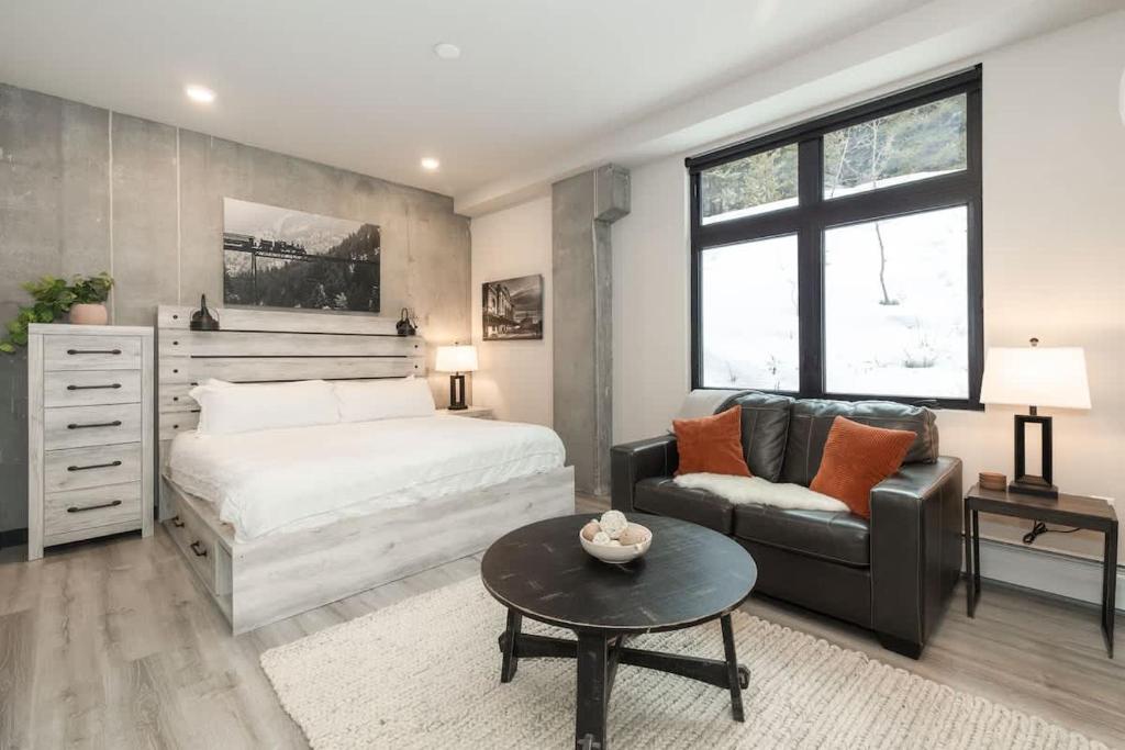 a bedroom with a bed and a couch and a table at NEW Ski-In Ski-Out Romantic Studio for Two in Winter Park