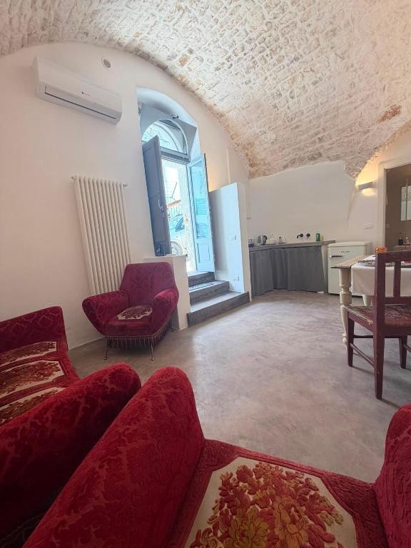 a living room with red couches and a table at Casa Maresca in Ostuni