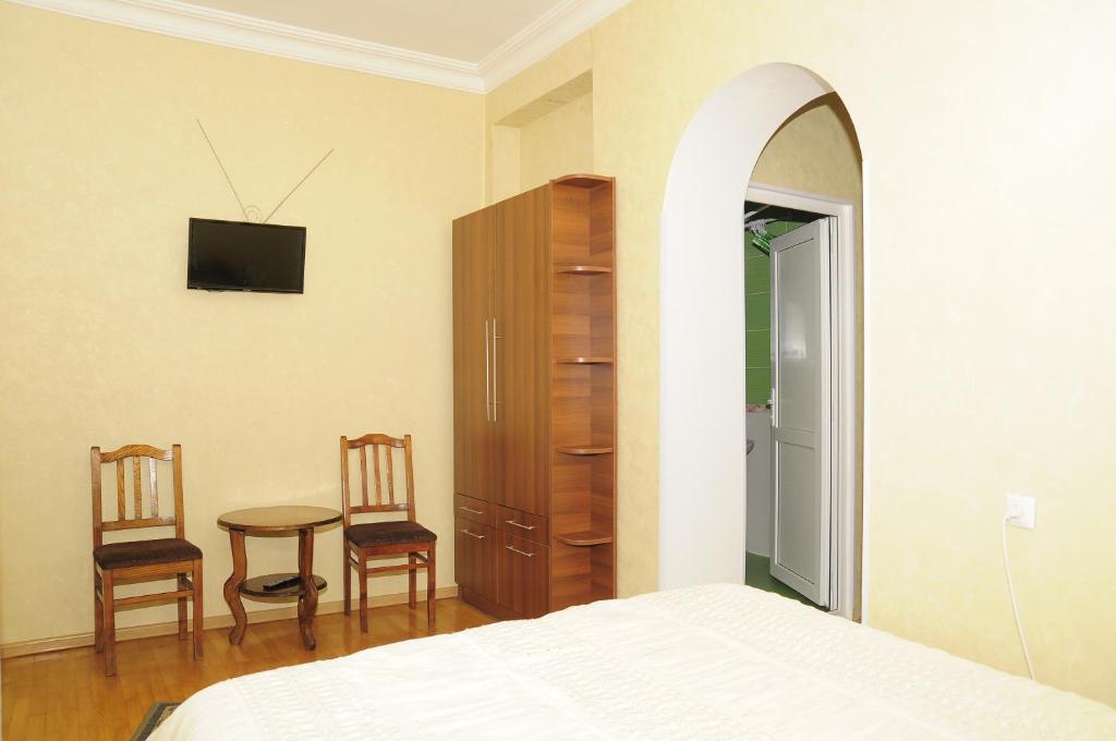 a bedroom with a bed and a table and chairs at Grimis Villa in Borjomi