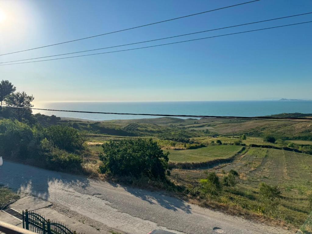 an empty road with the ocean in the background at General's Beach House in Kavajë