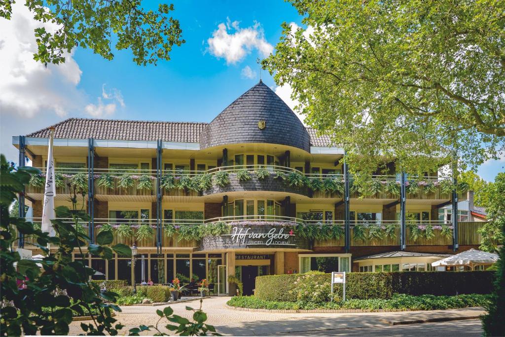 a large yellow building with a gambrel roof at Hotel Hof van Gelre by Flow in Lochem