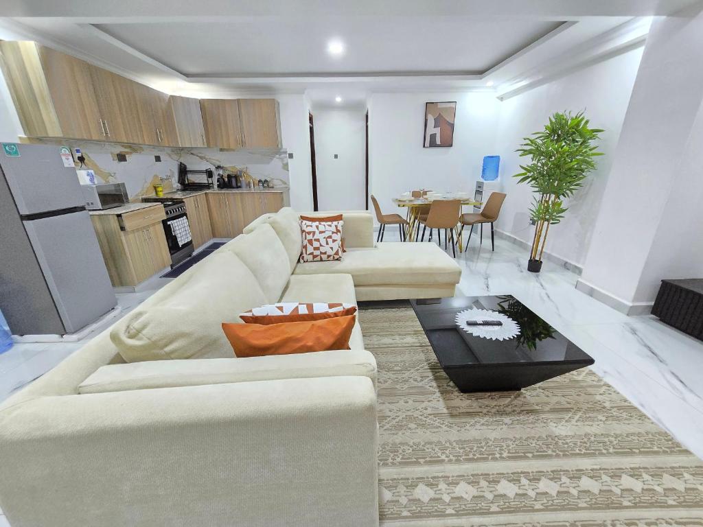 a living room with a white couch and a table at Marie's 2bed all-ensuite Tuffoam 310 in Kisumu