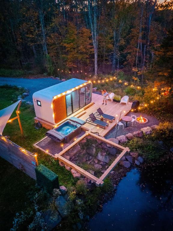 a person is standing on a tiny house on a deck at Romantic tiny Pod for Two HotTub Pond FirePit in Haines Falls