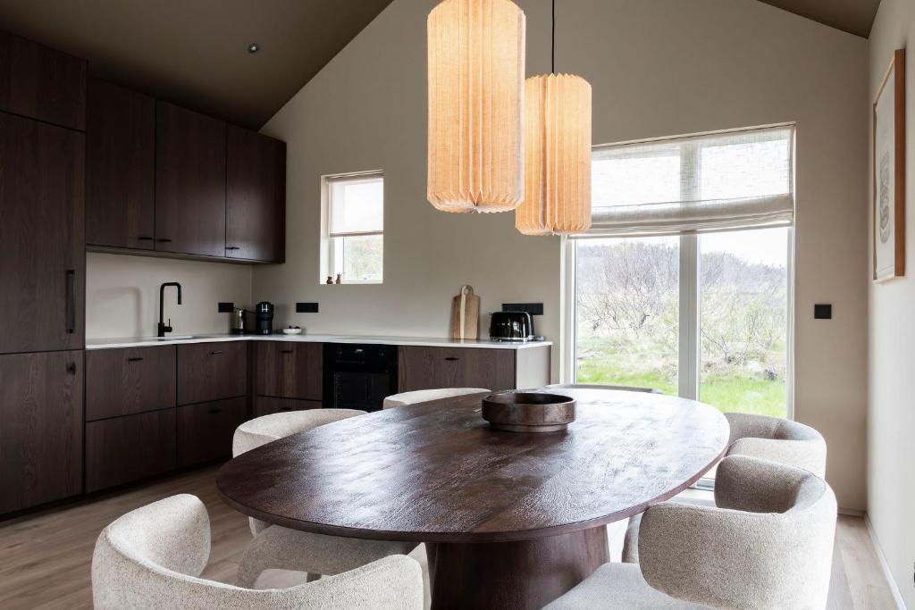 a kitchen with a wooden table and chairs at Modern Cabin with Hot Tub & Mountain views in Varmaland