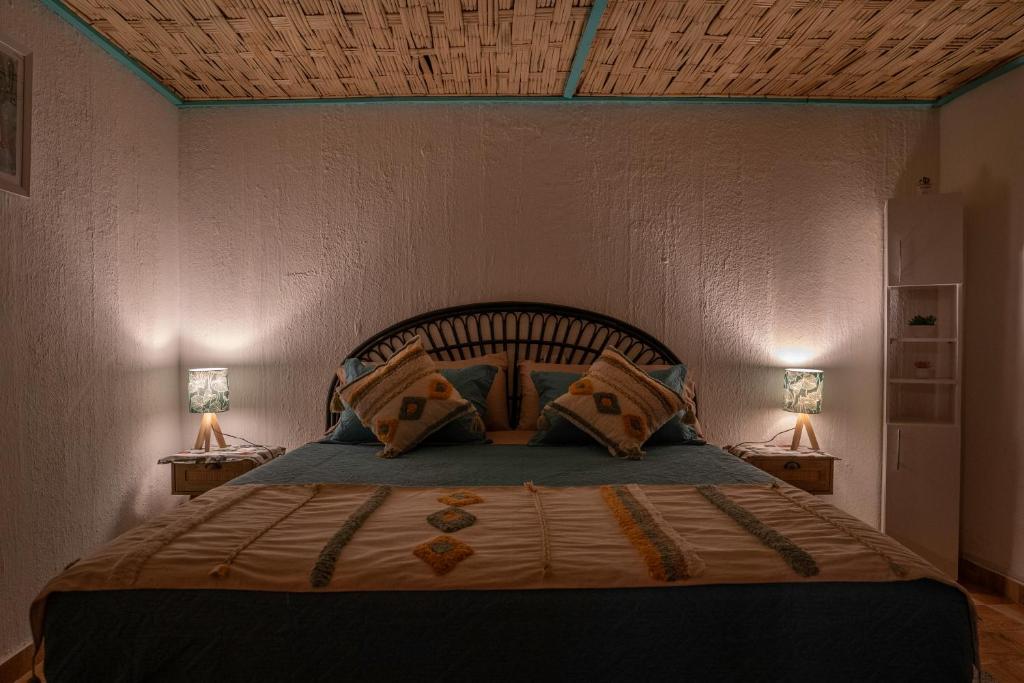 a bedroom with a large bed with two lamps at Karrizo lodge in San Pedro de Atacama