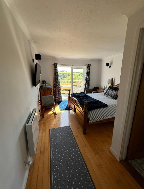 a bedroom with a bed and a window at Valley View in Port Isaac