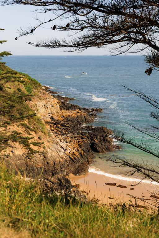 a view of the ocean from a hill with a beach at Villa vue Mer- grand jardin -cuisine d'été- 4 chambres- Vidéo projecteur in Planguenoual