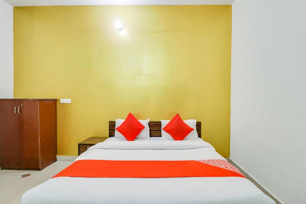 a bedroom with a large bed with red pillows at Hotel O by OYO Olive in Rohtak