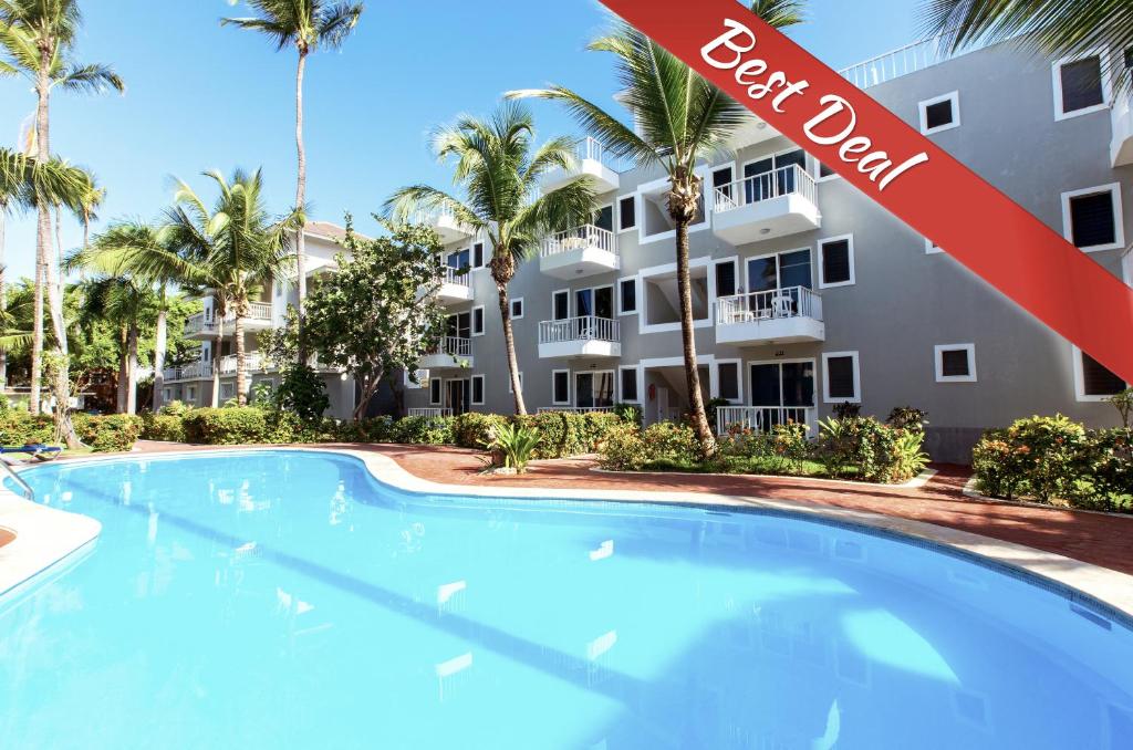 a swimming pool in front of a apartment building at FIESTA DEL CARIBE - LOS CORALES beach in Punta Cana