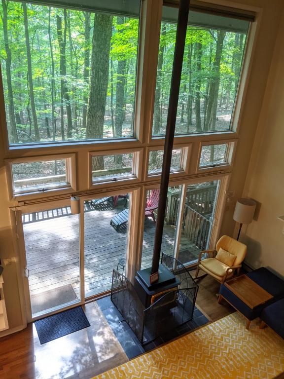 a living room with a fireplace and a large window at Autumn Wings - Propane Grill, Wifi, Kid Friendly, King Bed, Games, Screen Porch, Pool Access, Hiking in Berkeley Springs