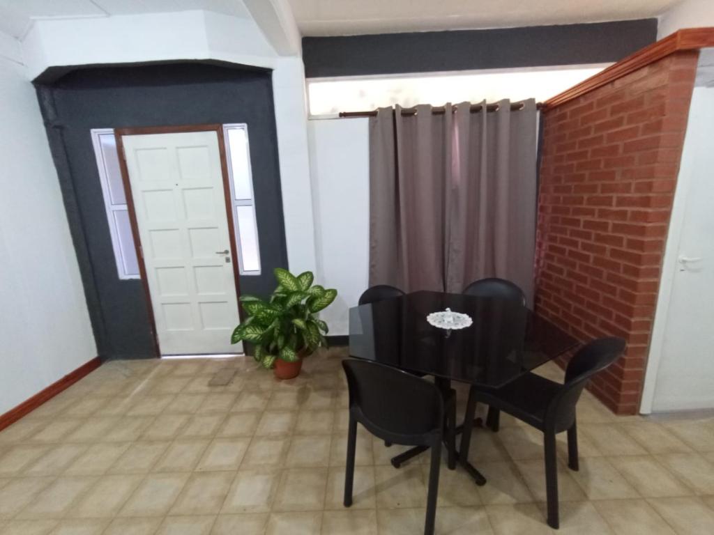a dining room with a black table and chairs at Casa jardin 2 in Jardín América