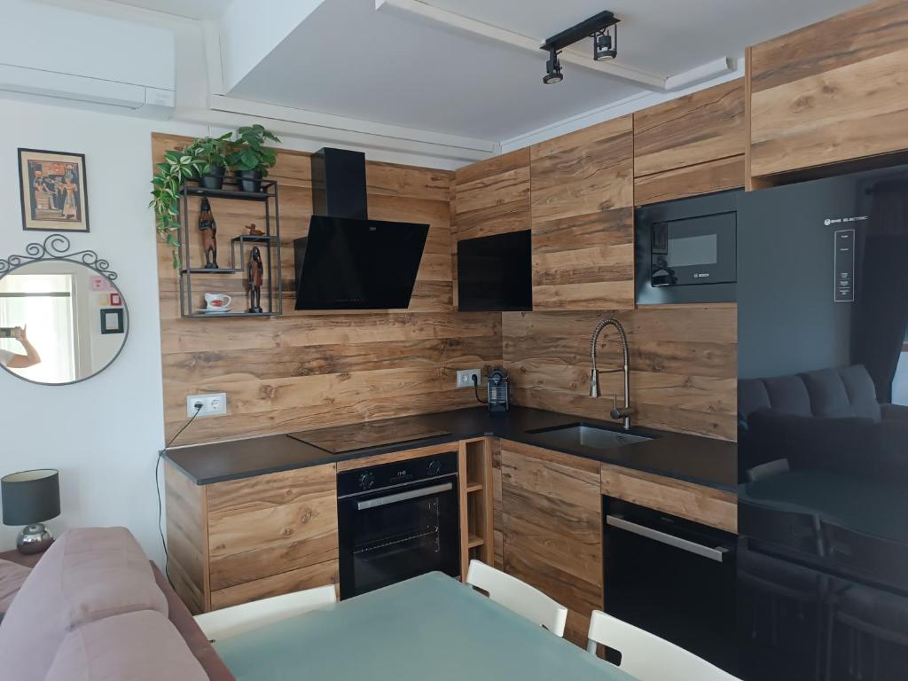 a kitchen with wooden walls and a sink and a table at Suite Poblamar in Pobla de Montornés