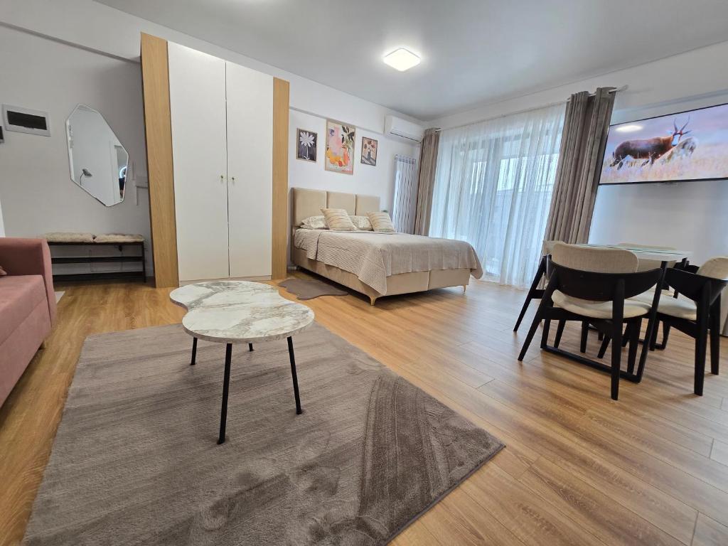 a bedroom with a bed and a living room with a table at Studio S23 in Piatra Neamţ