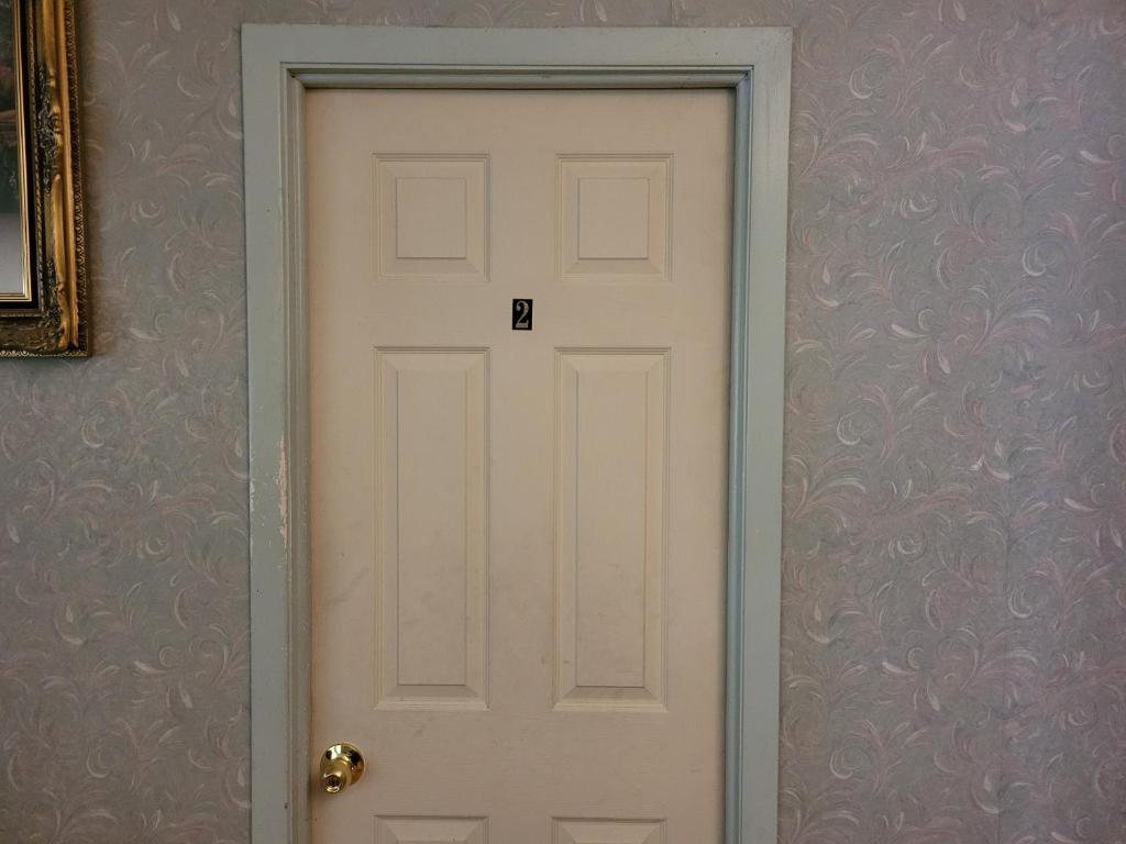 a white door in a room with a purple wall at Sleiman's Guest House in Windsor