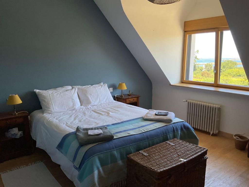 a bedroom with a bed with pillows and a window at Ti Toenn et spa in Landéda