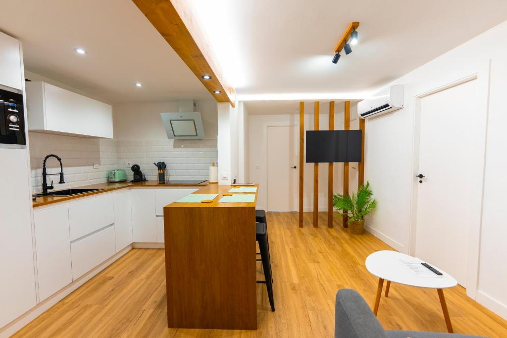 a kitchen with white cabinets and a wooden island at LAR DE SEFA in Redondela