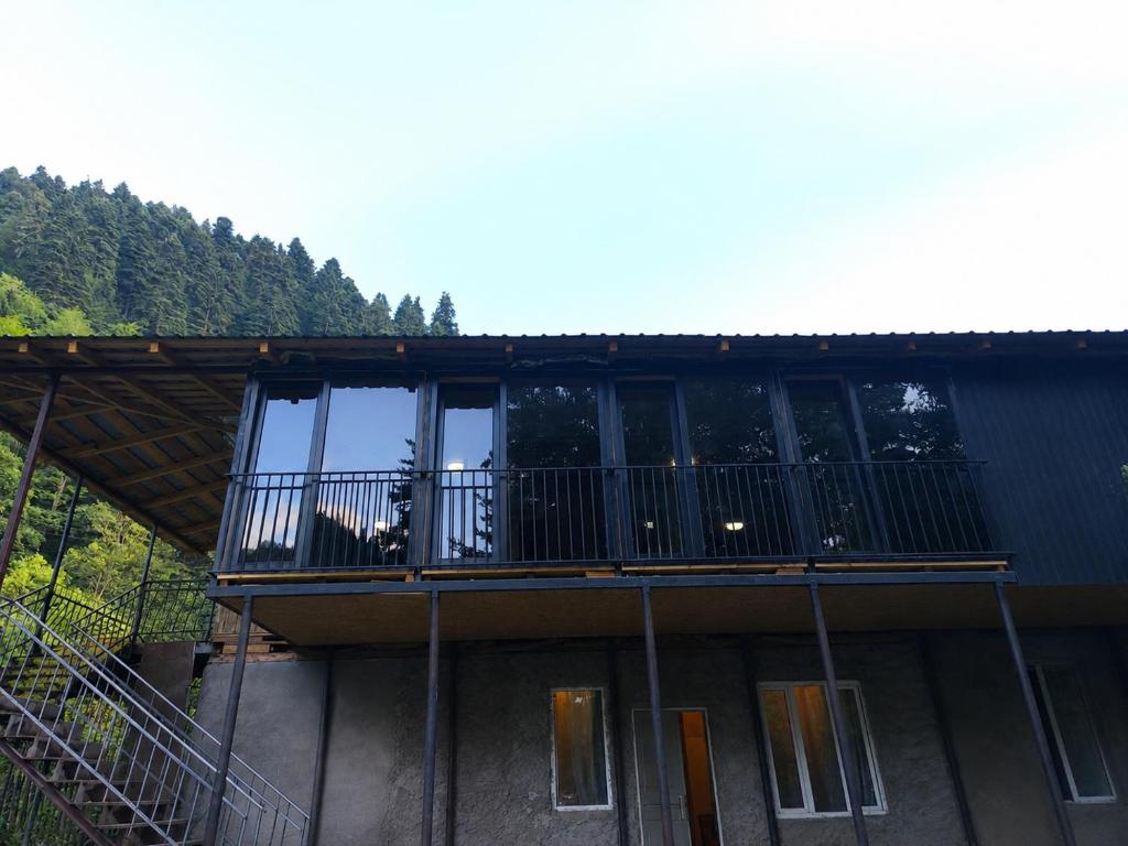a house with a balcony with a dog on it at guest house udziro in Oni