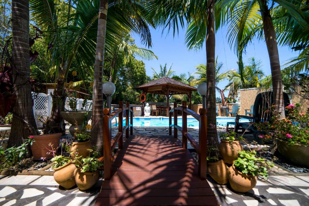 勒唐蓬的住宿－Fleur de vanille，一条通往棕榈树游泳池的路径