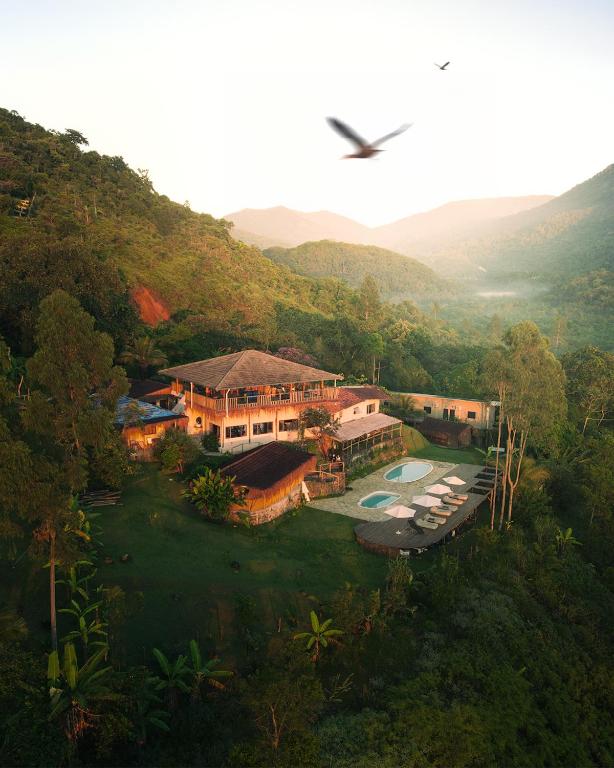 an aerial view of a house in a mountain at Mōmento Itamambuca in Ubatuba