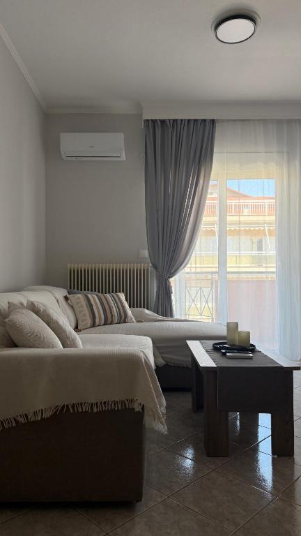 a bedroom with two beds and a table and a window at Heleni's Apartment in Aridaia