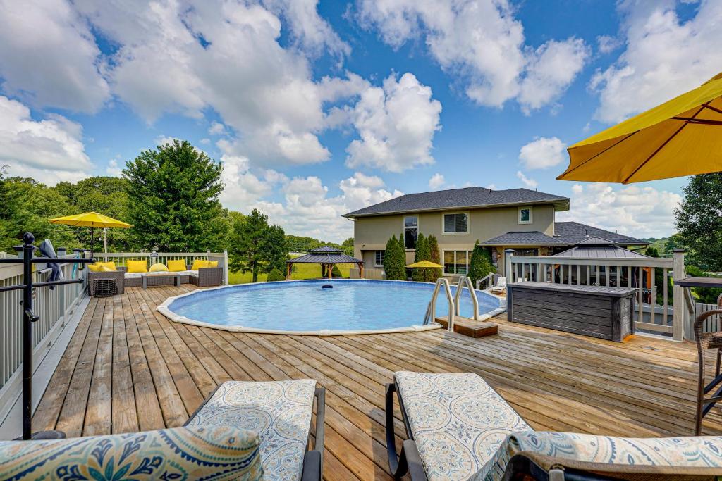 a deck with a pool and chairs and an umbrella at Private Getaway! Massive Springfield Area Home in Rogersville