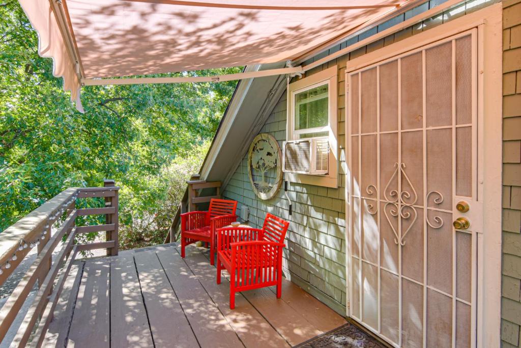 a porch with red chairs and a door at Walk to Downtown Chico! Tree-Lined Apt w/ Deck in Chico