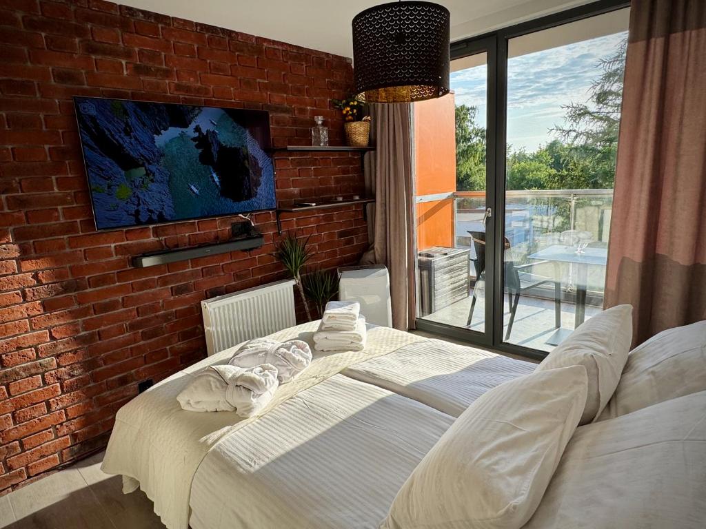 a bedroom with a bed and a brick wall at Sea Power Studio Loft in Jastrzębia Góra