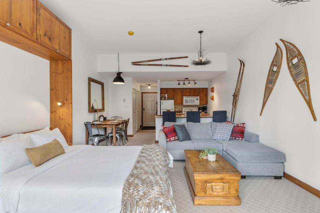 a living room with a large bed and a couch at Trailside Escape a Ski-In Ski-Out Studio in SilverStar in Vernon