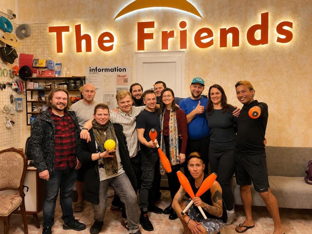 a group of people posing for a picture under thefriends sign at The Friends Hostel & Sauna in Kutaisi