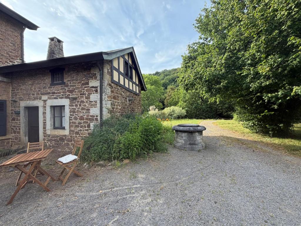 a brick building with a picnic table and a bench at Le Petit Fournil d'Aywaille in Aywaille