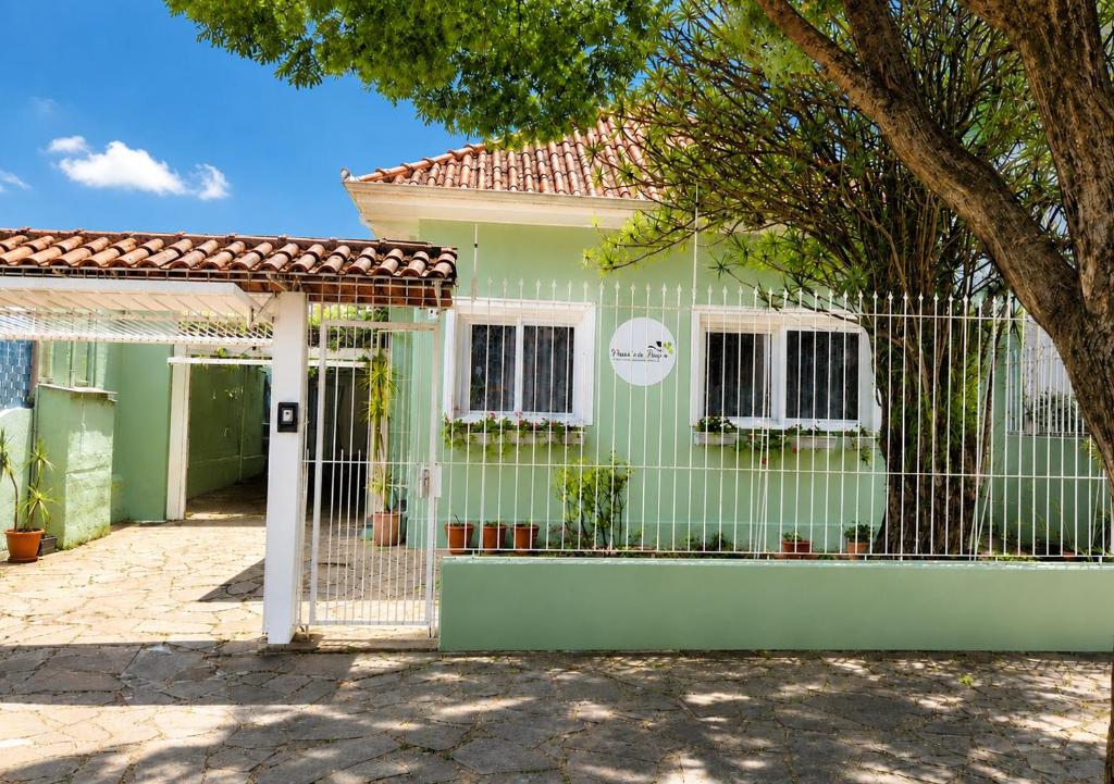 a green house with a gate in front of it at Pousada do Parque in Porto Alegre