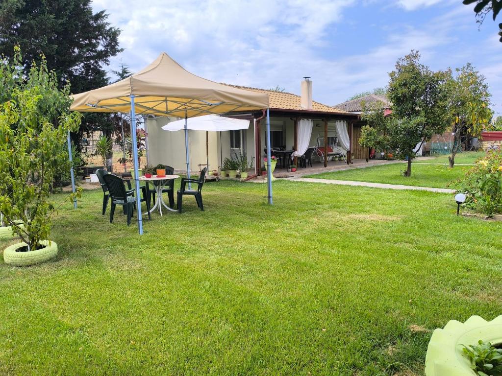 a table and chairs under a tent in a yard at Maria's House in Keramoti