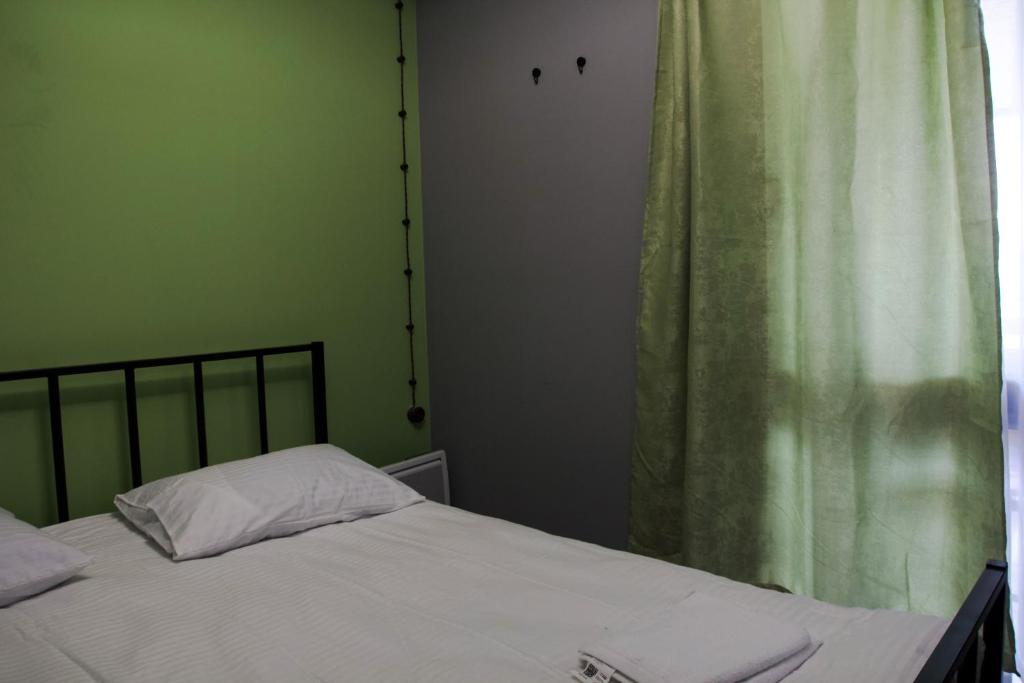 a bedroom with a bed and a green curtain at Villatun in Stepʼanavan