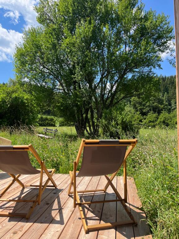 two chairs on a deck with a tree in the background at Refugium Mitterbach in Mitterbach