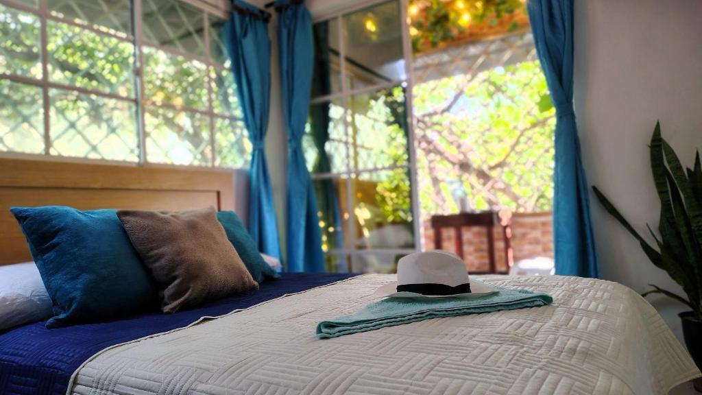 a hat sitting on top of a bed with a window at Guadalia Living Smr in Santa Marta