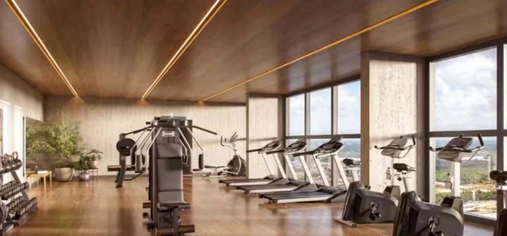 a gym with a row of treadmills and ellipticals at Beach GAV Resort in Salinópolis