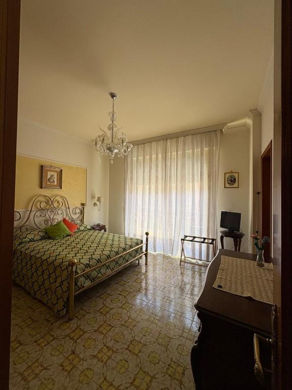 a bedroom with a bed and a chandelier at Holy family in Pachino