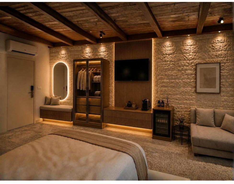 a bedroom with a bed and a couch and a mirror at Via Maria Boutique Suites - Free Parking in Haifa
